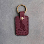 Sangria red leather keychain debossed with a cat looking up above the name Mochi's and the word STAFF