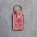 Parisian blossom pink leather keychain debossed with a curled sleeping cat above the name Mochi's and FAVORITE