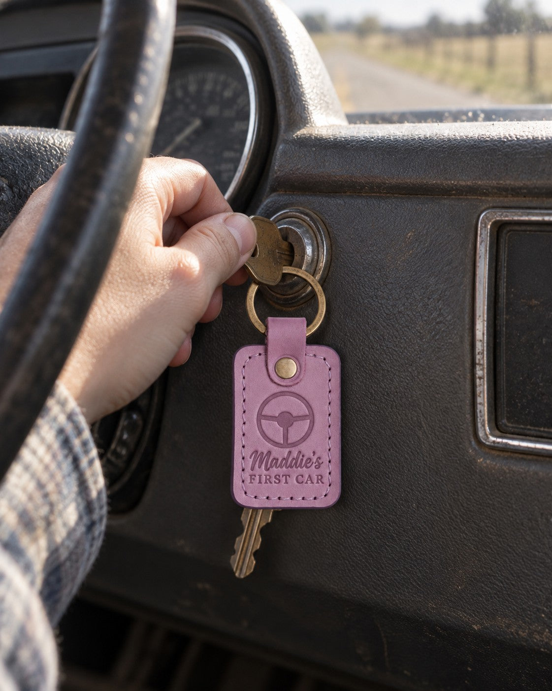 Lilac Maddie's FIRST CAR keychain on a new set of car keys held out in an open palm