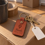Tan Noah Since 2004 keychain on a first car key held out in an open palm beside a driveway