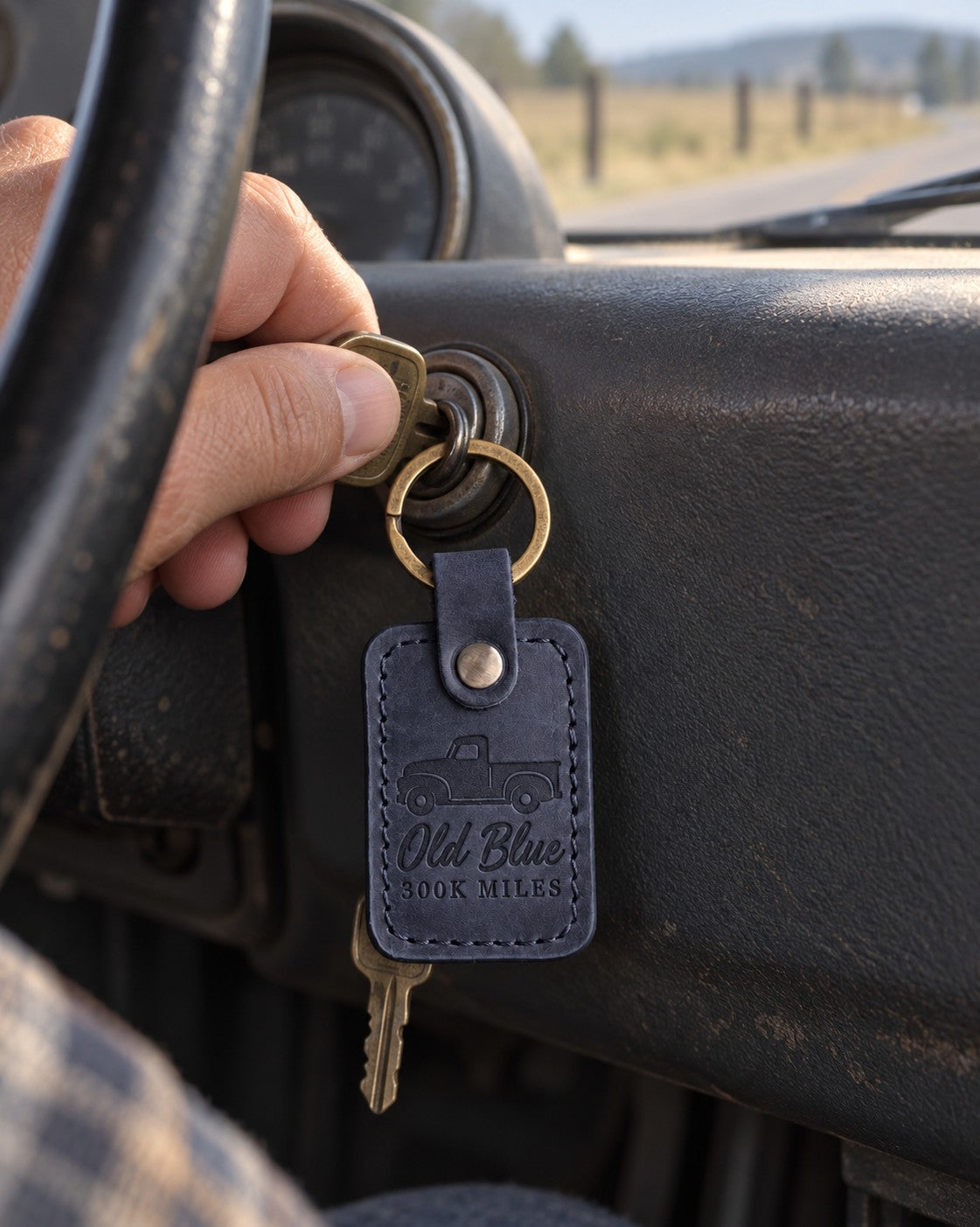 Navy Old Blue 300K MILES keychain hanging from the ignition of a well-used pickup