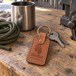 Walter VETERAN keychain in caramel leather on a set of truck keys resting on a folded flannel shirt