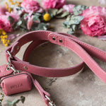 Pink leather dog leash in Parisian Blossom with a matching poop bag holder, both with the name Bella