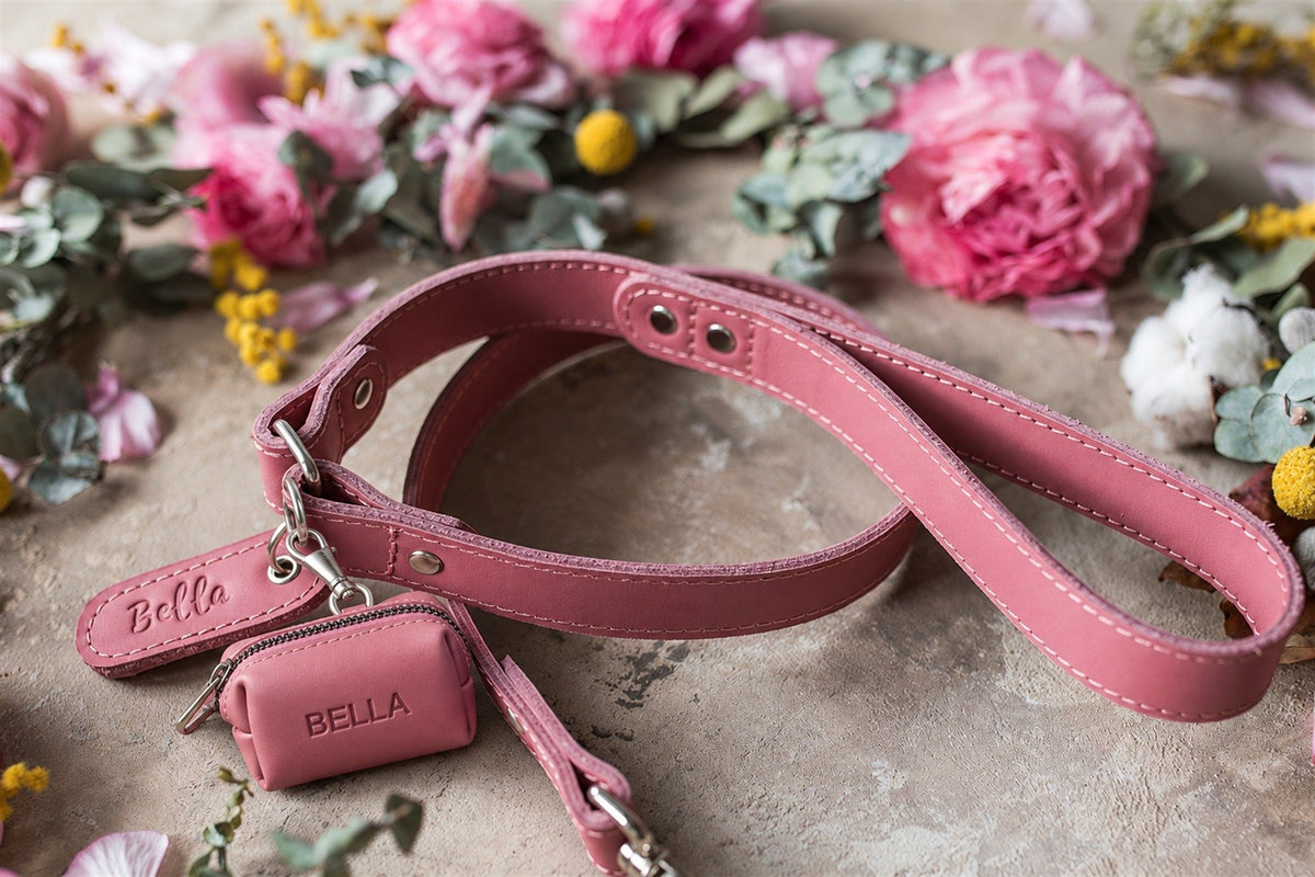 Pink leather dog leash in Parisian Blossom with a matching poop bag holder, both with the name Bella