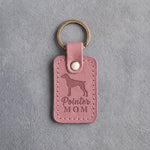 Parisian Blossom pink leather keychain debossed with a German Shorthaired Pointer silhouette and the words Pointer MOM, on gray concrete