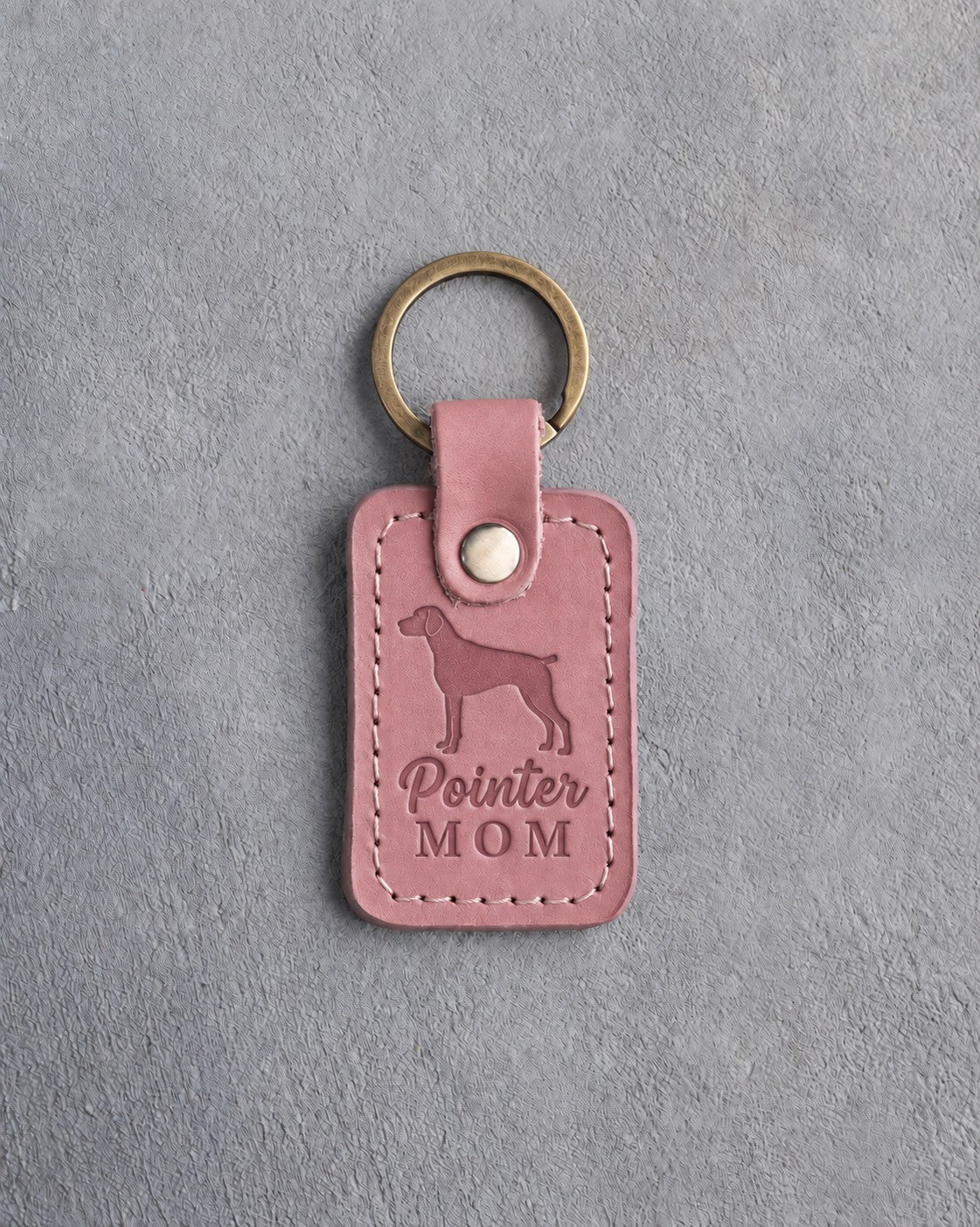 Parisian Blossom pink leather keychain debossed with a German Shorthaired Pointer silhouette and the words Pointer MOM, on gray concrete