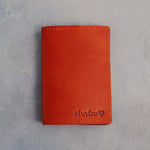 Poppy Red leather passport cover with a name in cursive with a heart pressed into the bottom corner