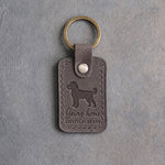 Country gray leather keychain debossed with a cockapoo above Going home and LOVED ALREADY, on gray concrete