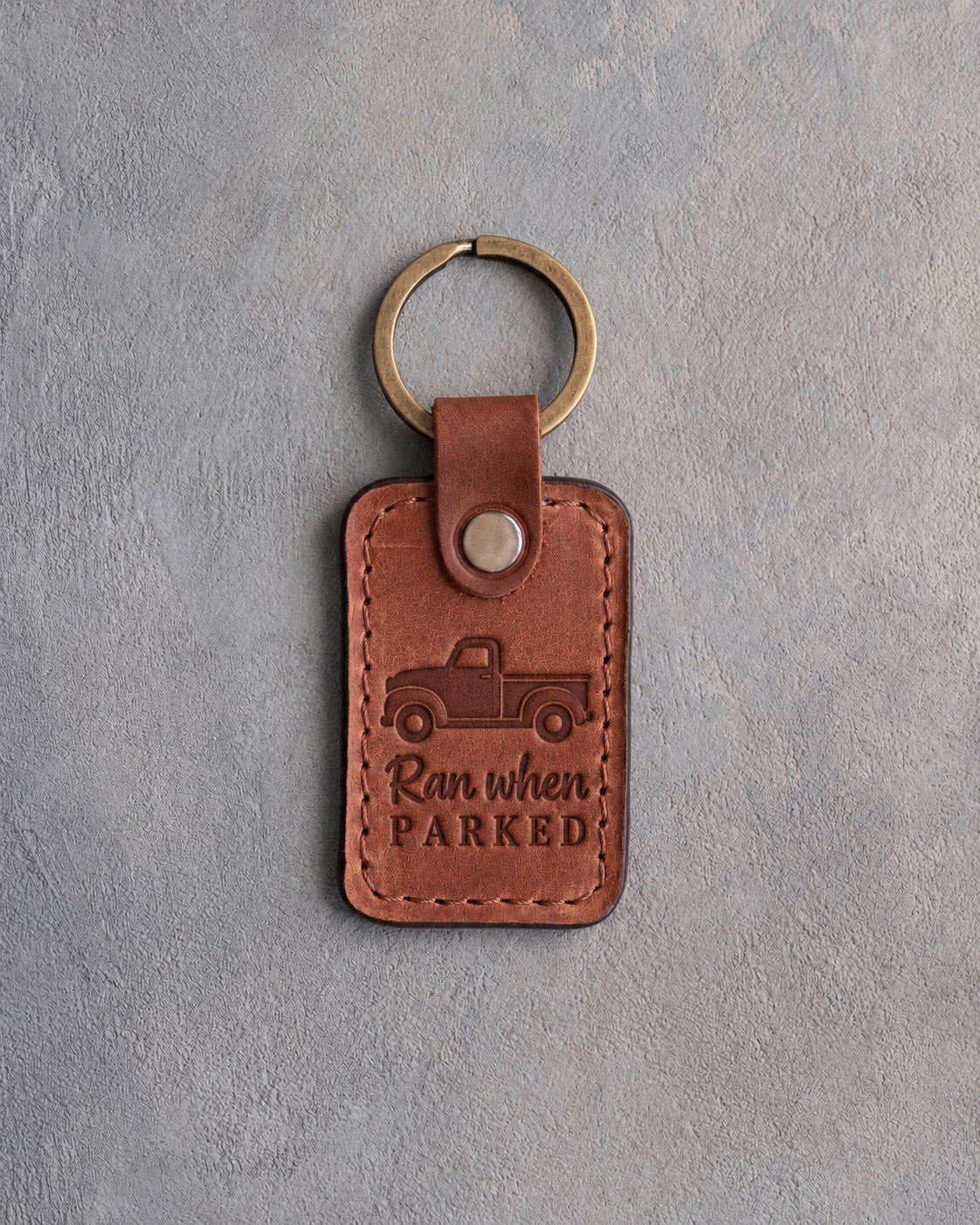 Arizona tan leather keychain debossed with a classic pickup truck above Ran when and PARKED
