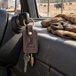Dark espresso Ranch GRANDPA keychain on the ignition key of a ranch pickup, work gloves and fence pliers on the dash