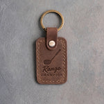 Sicilian brown leather keychain debossed with a golf driver above the words Range CHAMPION, on gray plaster