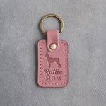 Parisian Blossom pink leather keychain debossed with a Rat Terrier silhouette and the words Rattie MOM, on gray concrete