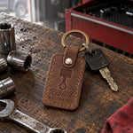 Brown Rebuilt BY HAND keychain hanging from the ignition of a classic car with a worn bench seat