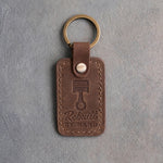 Sicilian brown leather keychain debossed with a piston and connecting rod above Rebuilt and BY HAND