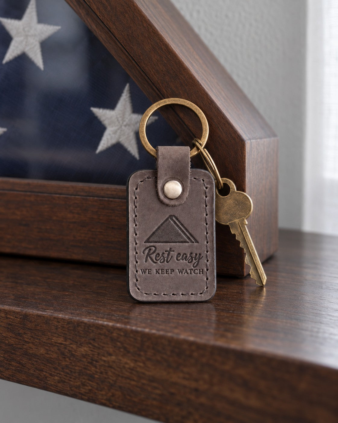 Gray Rest Easy keychain laid on a granite ledge in soft morning light