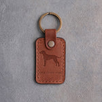 Arizona tan leather keychain debossed with a Rhodesian Ridgeback silhouette above THE LION DOG, on gray concrete
