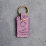 Lilac leather keychain debossed with a stethoscope above the words New nurse and RN SINCE 2026, on gray concrete