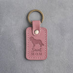 Parisian Blossom pink leather keychain with a debossed Saint Bernard and the words Saint MOM, on gray concrete