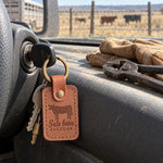 Caramel Sale barn REGULAR keychain on the ignition key of a ranch pickup, work gloves resting on the dash