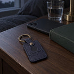 Two navy Same Moon Different Sky keychains on separate key rings beside a handwritten letter at night