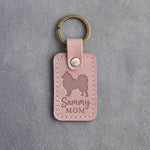 Blush pink leather keychain with a debossed Samoyed and the words Sammy MOM on gray concrete