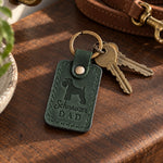 Forest green Schnauzer Dad leather keychain held in a warm everyday setting
