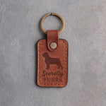 Arizona tan leather keychain debossed with a Rottweiler silhouette and the words Secretly PURRS, on gray concrete