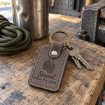 Gray Served 1988 TO 2008 keychain on a key ring beside a folded flag in a wooden display case