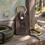 Dark espresso Shiba Dad leather keychain held in a warm everyday setting