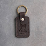 Dark espresso leather keychain debossed with a Shiba Inu silhouette and the words Shiba DAD, on gray concrete