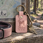 Blush pink Shiba Mom leather keychain placed in a warm everyday setting