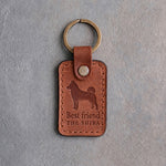 Arizona tan leather keychain debossed with a Shiba Inu silhouette above Best friend and THE SHIBA, on gray concrete