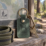 Forest green Shiba Scream leather keychain placed in a warm everyday setting
