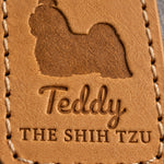 Close-up of Teddy in brush script and THE SHIH TZU pressed into Indian Summer tan full-grain leather beneath a Shih Tzu silhouette