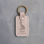 Gray sand leather keychain debossed with a sitting Siamese cat above the name Coco and SIAMESE