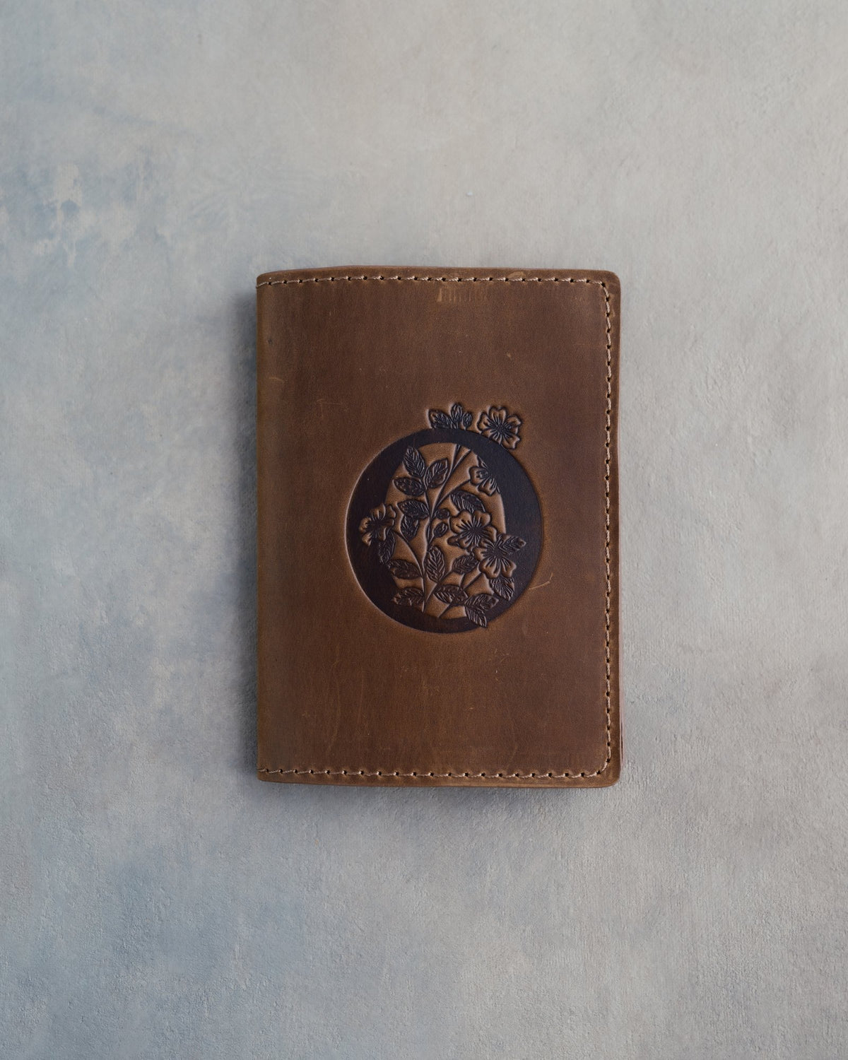 Sicilian Brown leather passport cover with a large floral initial O pressed into the front