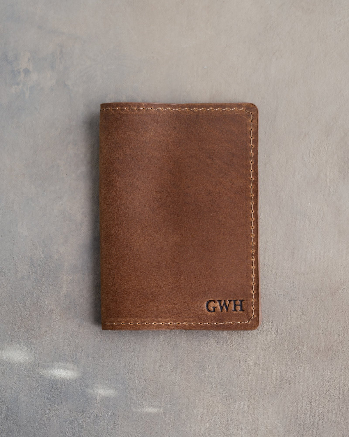 Sicilian Brown leather passport cover with the monogram GWH in straight capitals pressed into the bottom corner