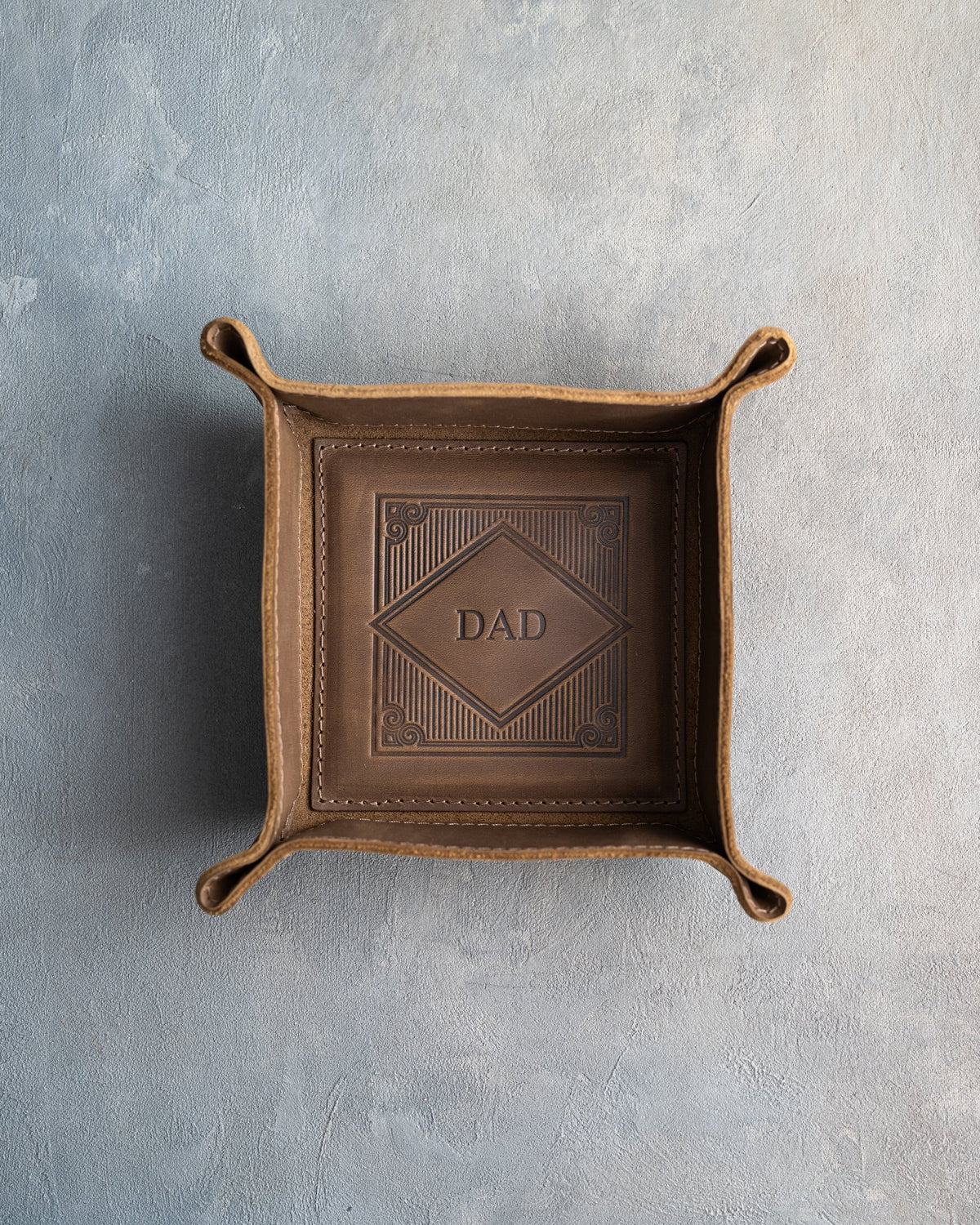 Sicilian Brown leather valet tray with snapped corners and the initials DAD pressed into the diamond frame, seen from above