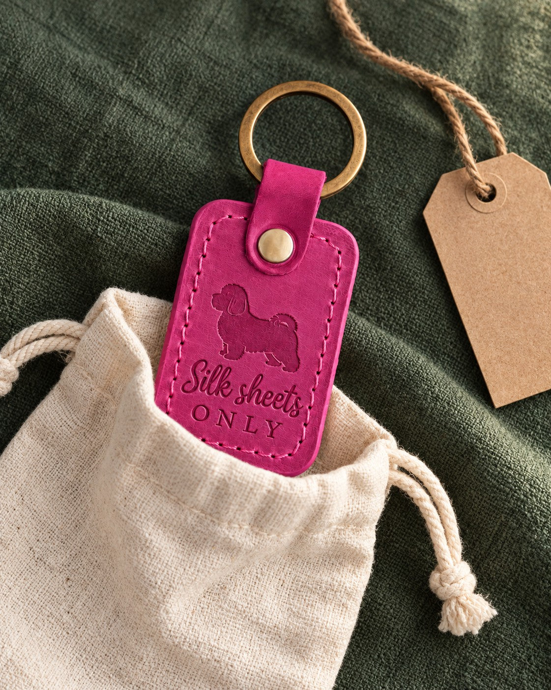 Fuchsia pink Silk Sheets Only leather keychain placed in a warm everyday setting