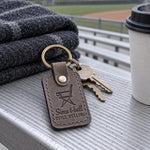 Gray Still Yelling keychain on car keys tucked into the cup holder of a folding sports chair