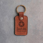 Arizona orange tan leather keychain debossed with a soccer ball and the words Snack duty TEAM MOM, on gray plaster