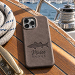Country Gray Mateo SNOOK iPhone case in full-grain leather on the worn teak cockpit table of a sailboat beside a coiled white dock line