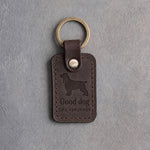Dark espresso leather keychain debossed with a springer spaniel above Good dog and THE SPRINGER, on gray concrete