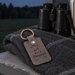 Gray Stargazer Since keychain hanging from a telescope case handle in a dark backyard lit by a red flashlight