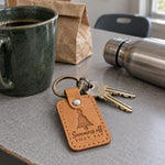 Summers Off They Say keychain in golden tan leather on a teacher's keys next to a planner open to July