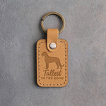 Indian Summer tan leather keychain debossed with an Irish Wolfhound silhouette and the words Tallest IN THE ROOM, on gray concrete