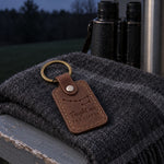 Brown Taught Me the Dipper keychain on a set of keys resting on a camp chair arm at twilight