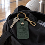 Green Thank You Coach keychain on a clipboard beside a whistle and a team card at the end of a season