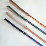 Four thin 5/8 in woven webbing leashes with leather handles