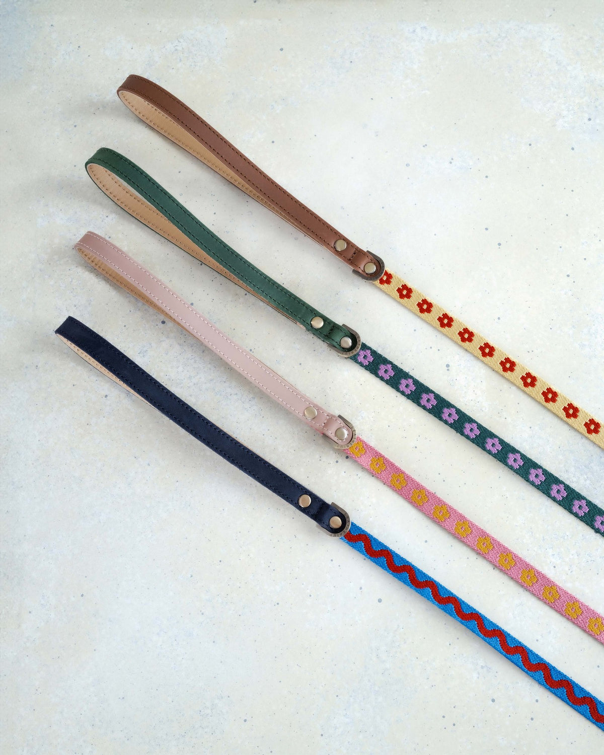 Four thin 5/8 in woven webbing leashes with leather handles